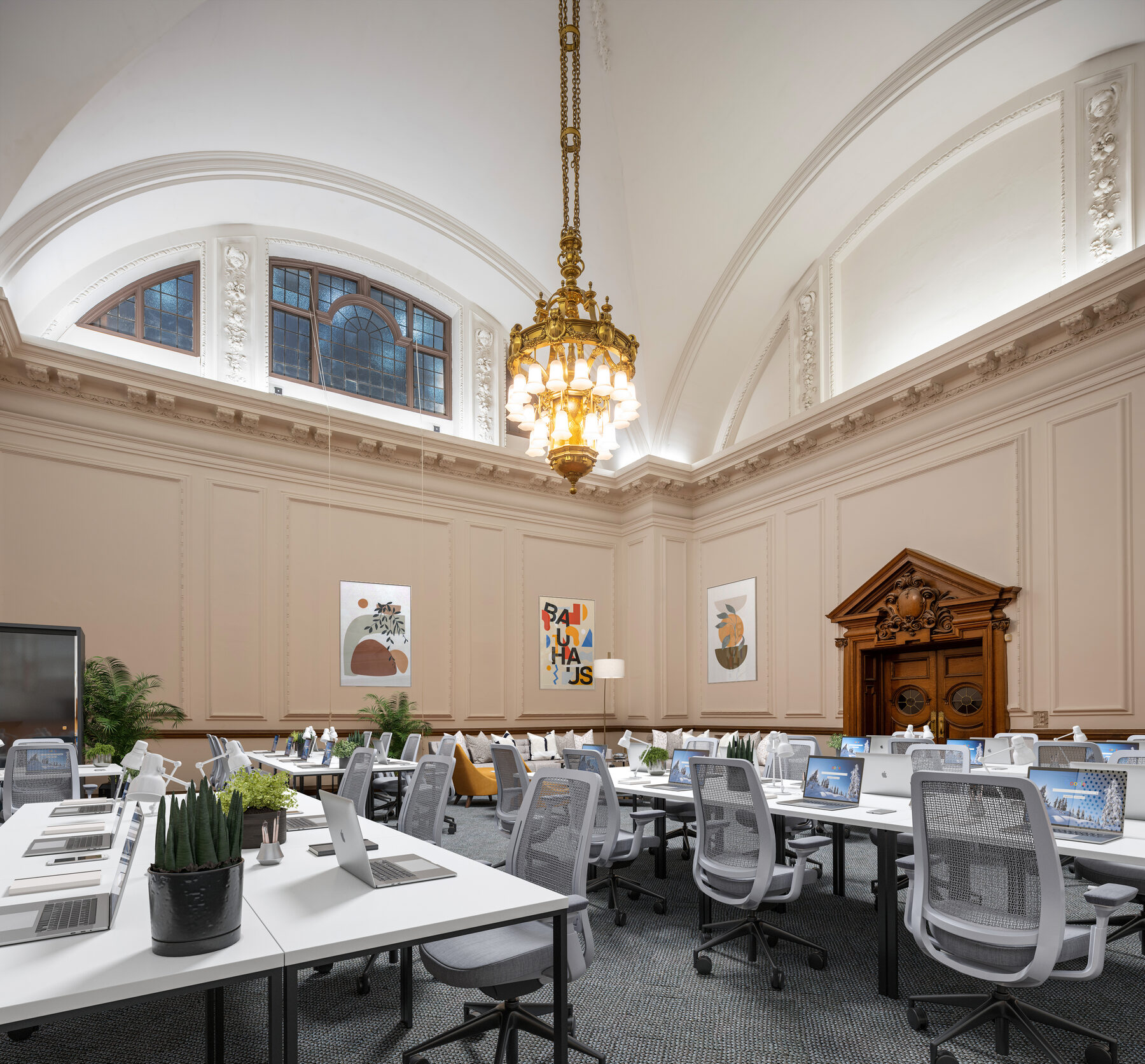 Holborn Town Hall ground floor office, staged with rows of desks under the heritage chandelier